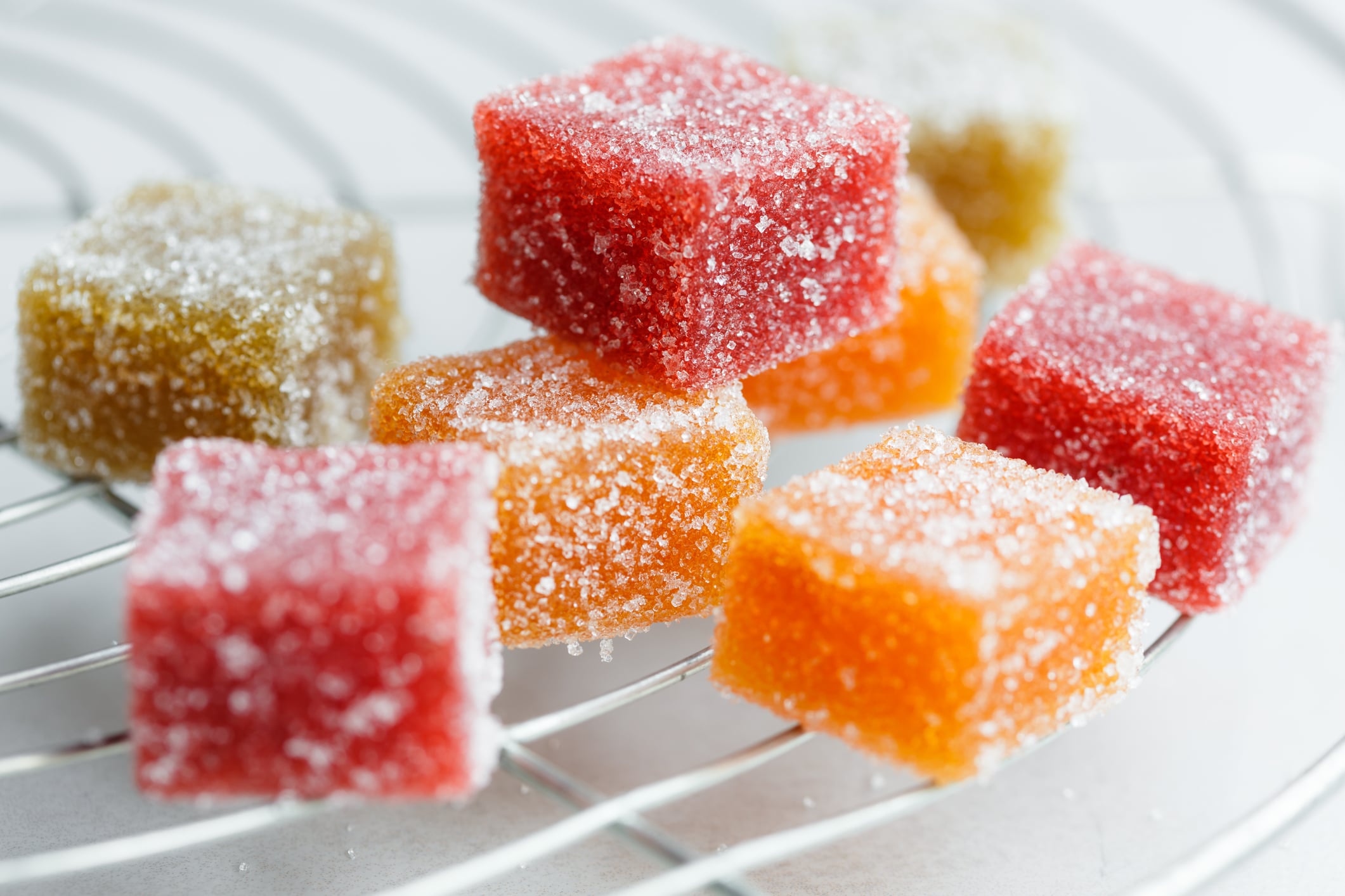 Easy Edibles: How to Make Weed Gummies For Beginners - Fruit cube jelly candy on cake rack - featured image